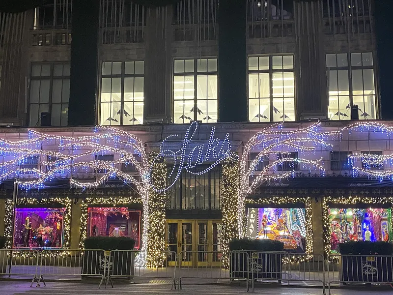 Saks Fifth Avenue facade with lighted trees and holiday windows at night