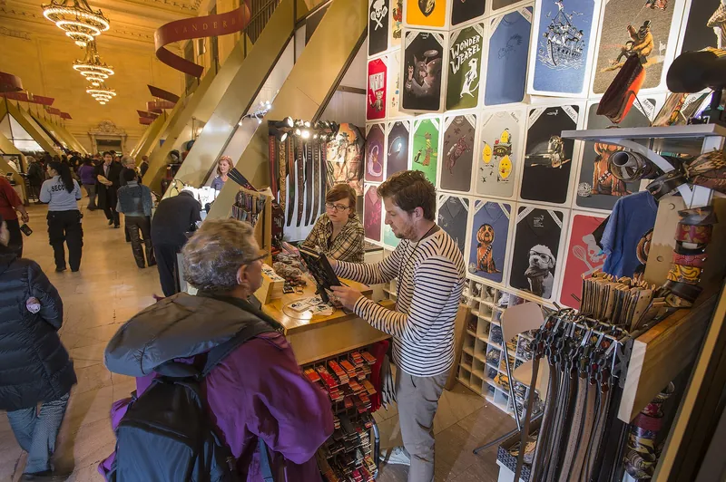 Shoppers at Holiday Fair stalls under Vanderbilt Hall chandeliers